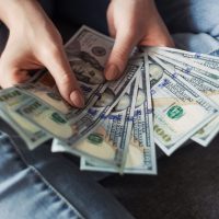 Pawn Person holding $100 bills